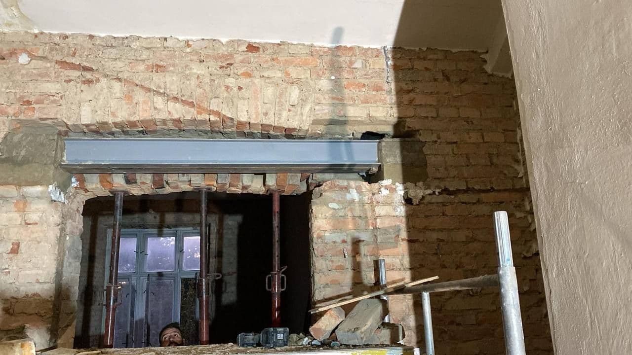 Ocelový nosník osazený jako překlad nad velkým otvorem v cihelné stěně.