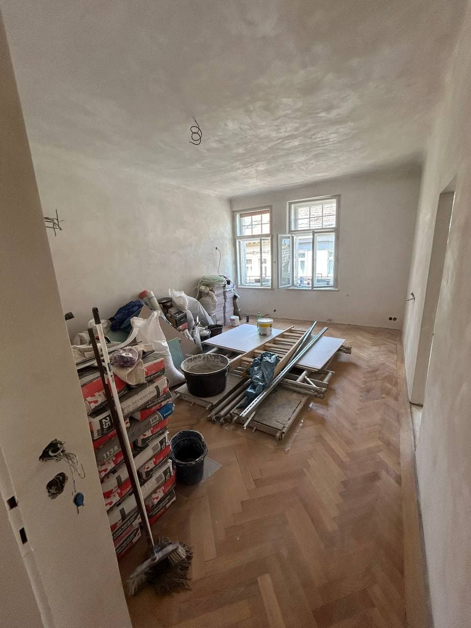 Místnost s parketovou podlahou během rekonstrukce.